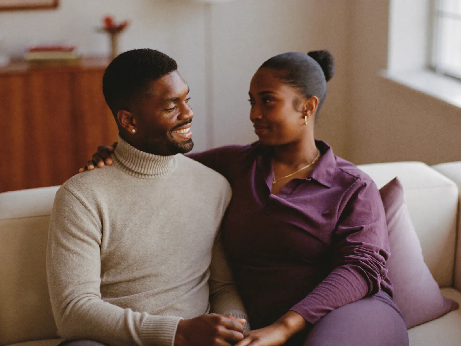 A couple sitting close together on a sofa, talking warmly